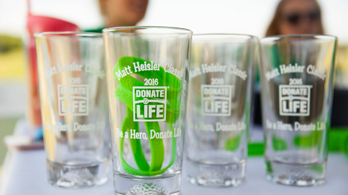 Glass cups that say Matt Heisler Classic 2016 sitting on a table with green wristbands in the cups.