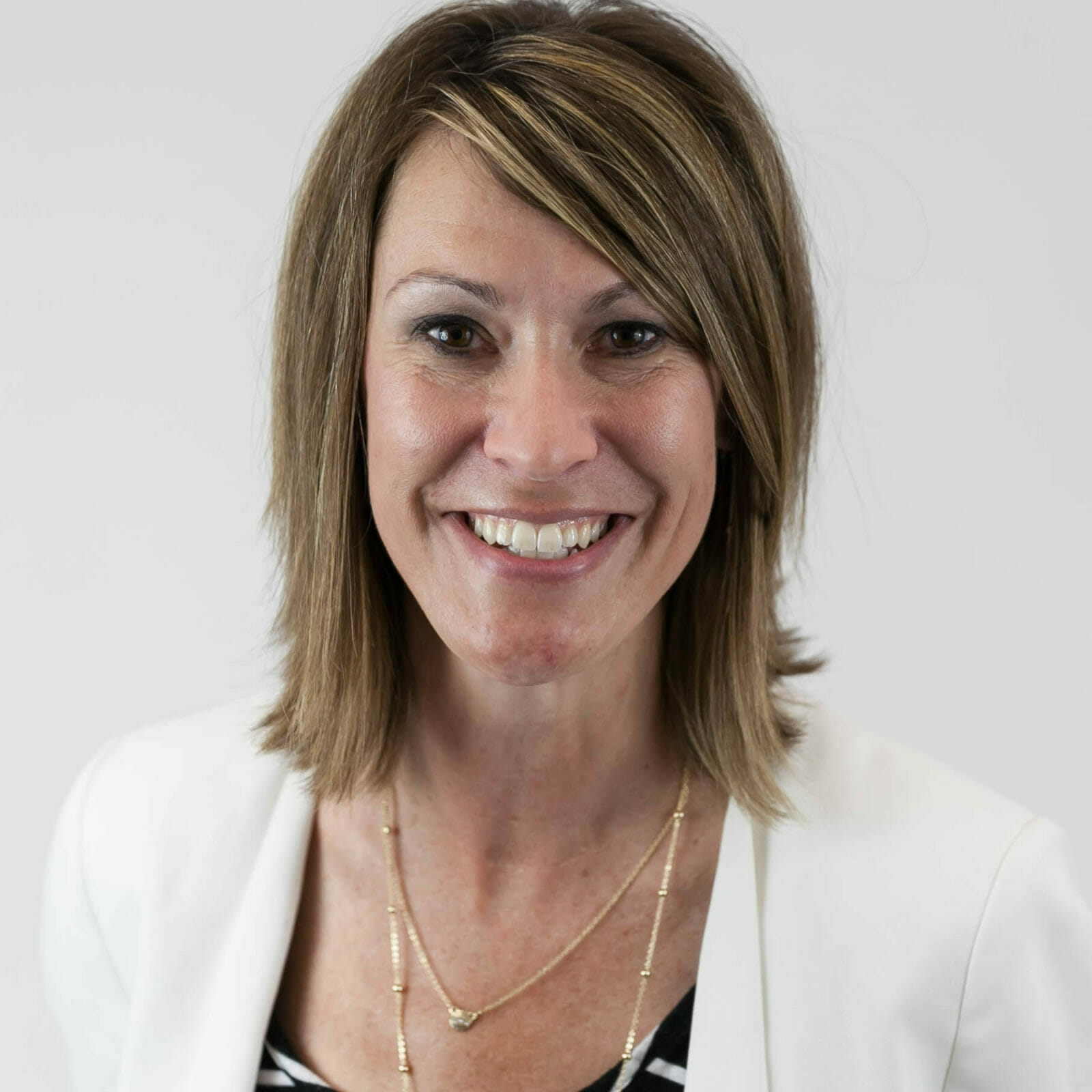 Jody Fischer wearing a white jacket and smiling