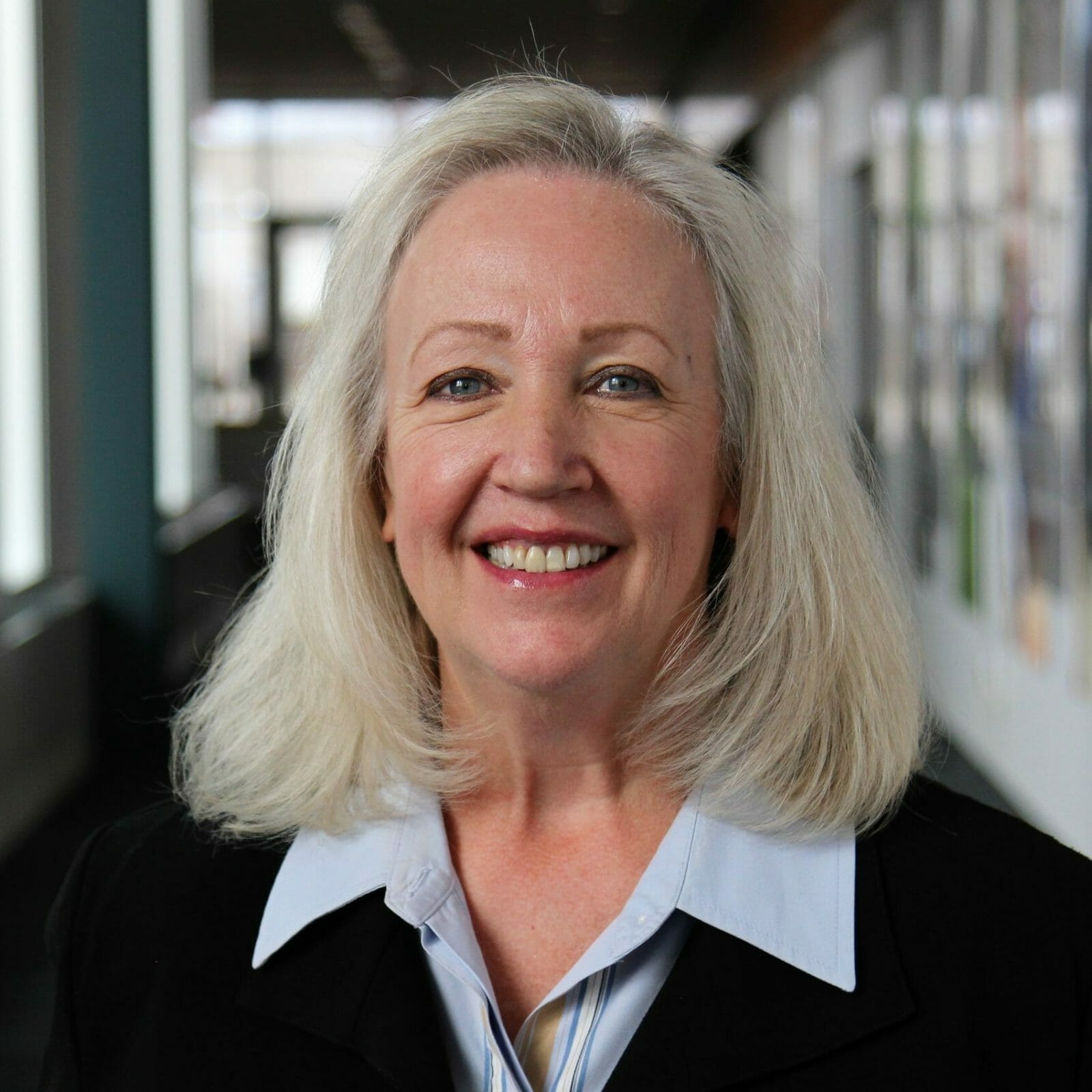 Kathy Selden wearing a black jacket and smiling