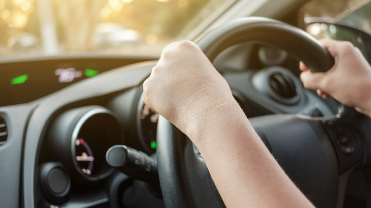 Manos agarrando el volante de un coche