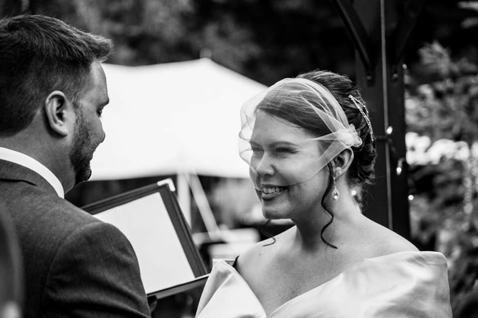 Bethany Travis Nolt wearing a veil standing at the altar with her husband