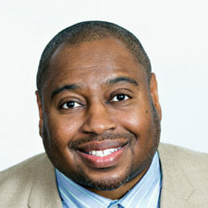 Man in suit and tie smiling at camera