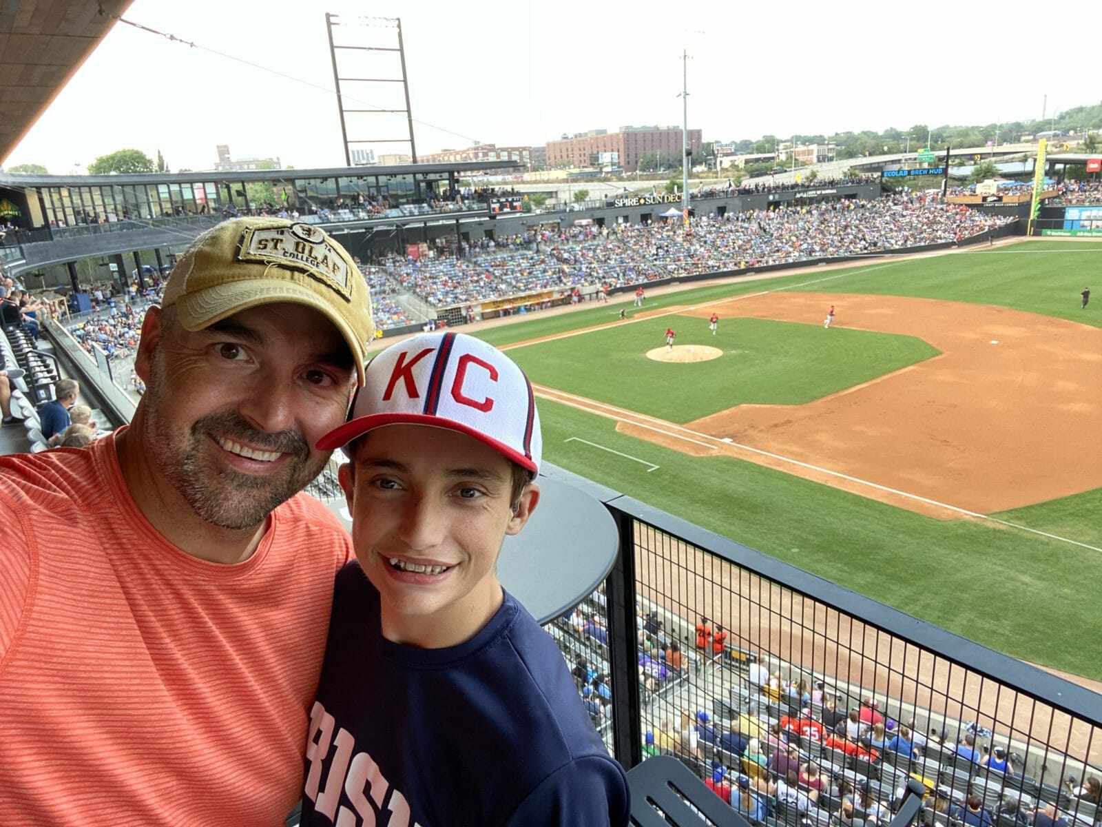 Chris y su hijo Mason sonriendo para un selfie en un partido de béisbol