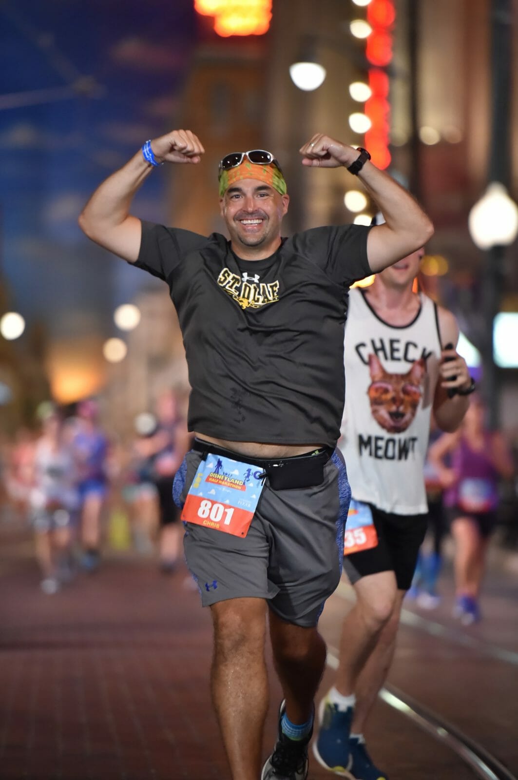 Chris corriendo la media maratón de Disneylandia, con los brazos en alto en señal de triunfo