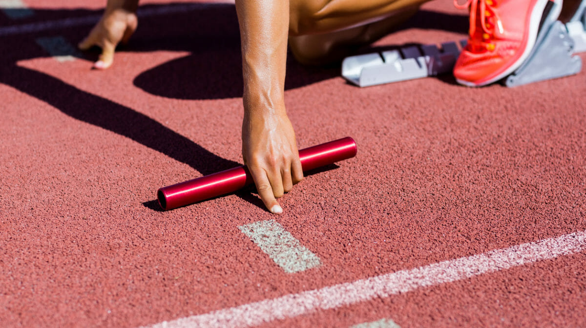 Atleta femenina preparada para iniciar la carrera de relevos