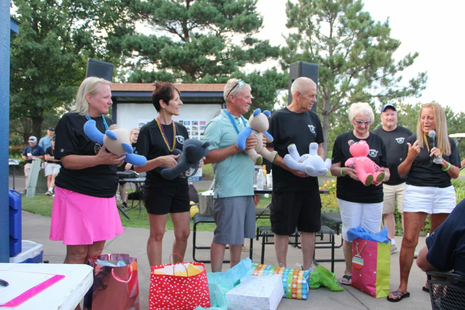 Five family members stand on stage, each with stuffed bear