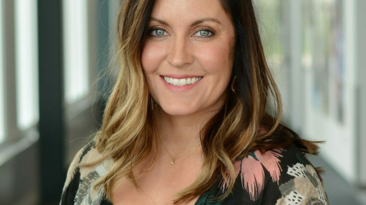 Woman in floral print shawl smiles at camera