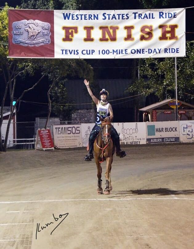woman celebrates at horse riding finish line