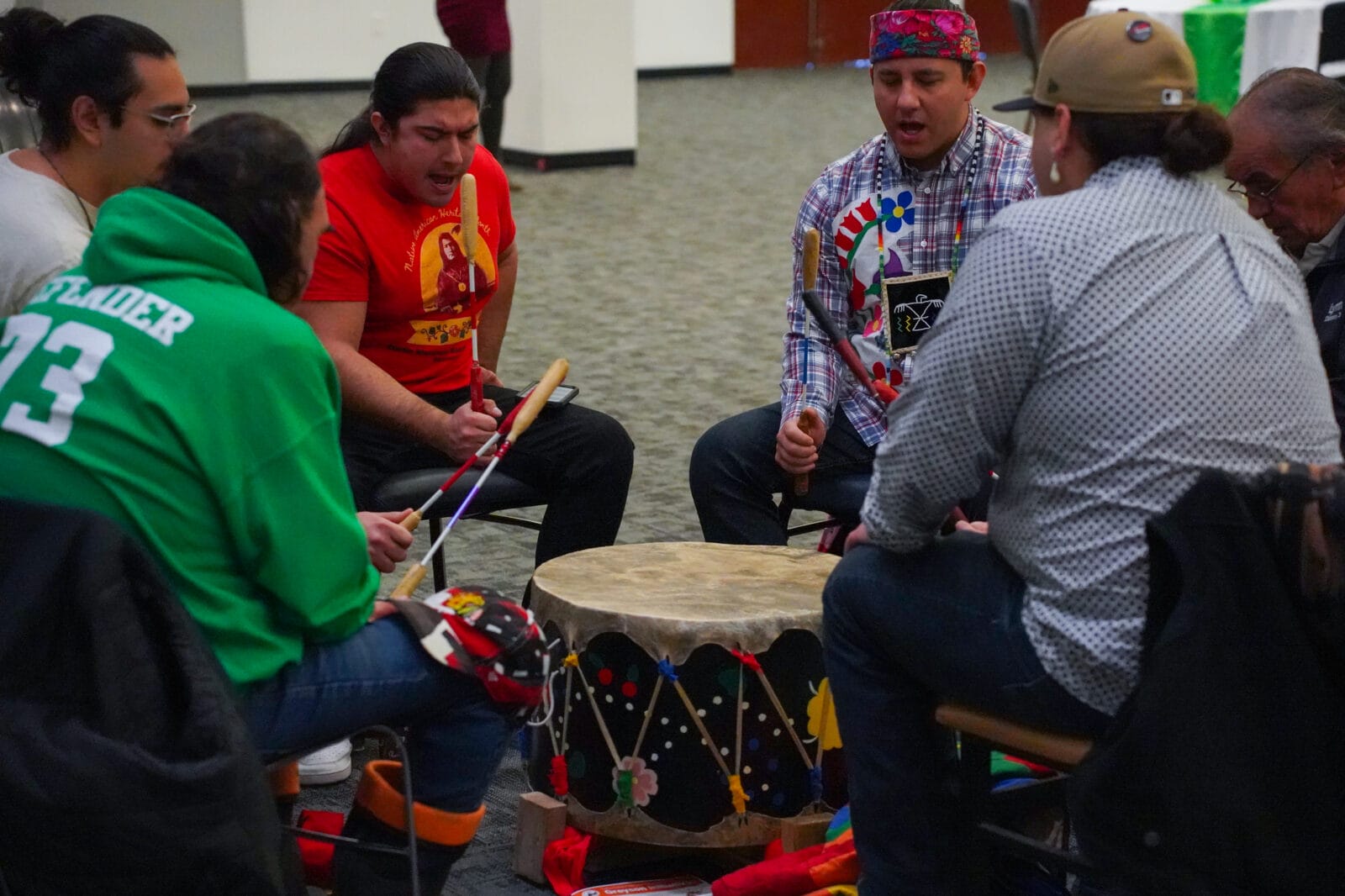 Six people play tribal drum at event.