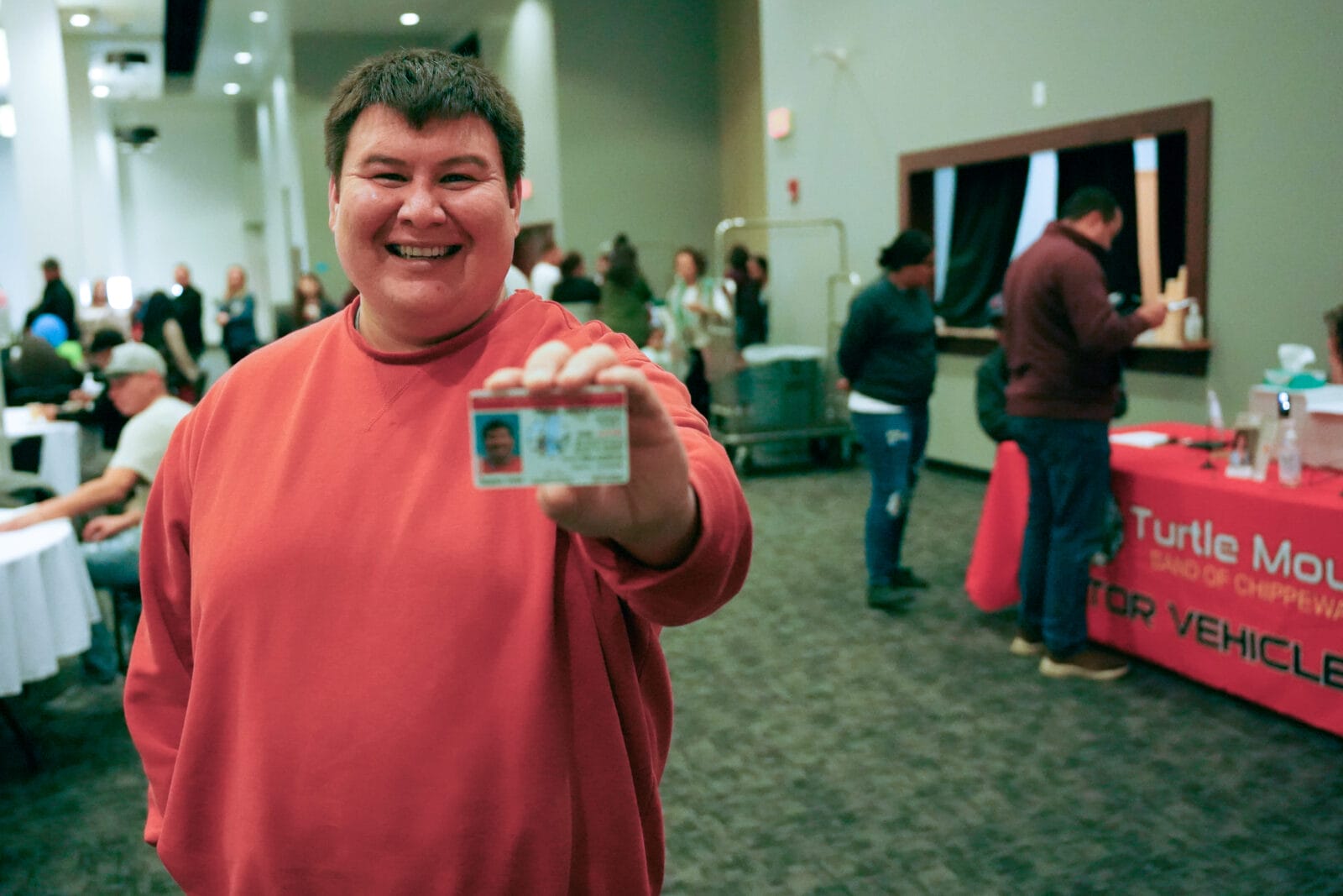 Un miembro de Turtle Mountain muestra orgulloso su carné con el registro de donantes.