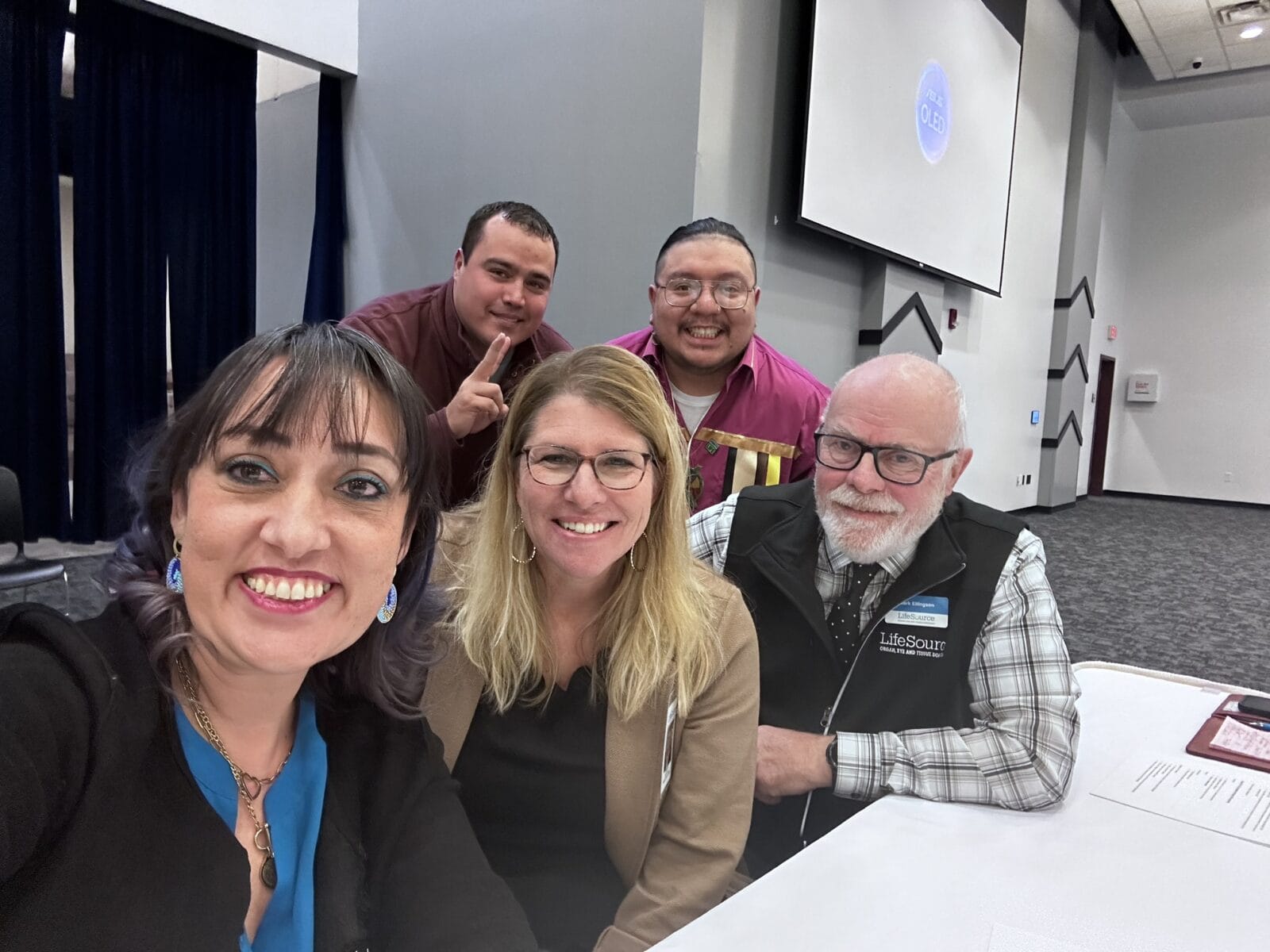 People smiling at camera in conference room